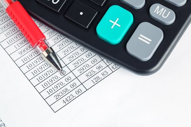 calculator and red pen on a digital report ,financial check concept