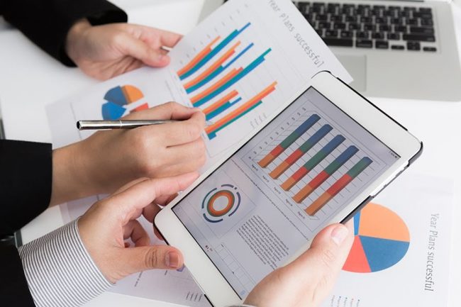 Close-up of  business team using digital tablet with financial diagram