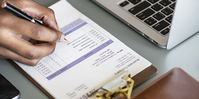 Closeup of business man checking tax invoice paper