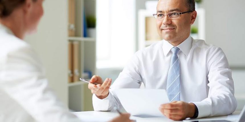 Portrait of mature businessman looking at his secretary while speaking to her
